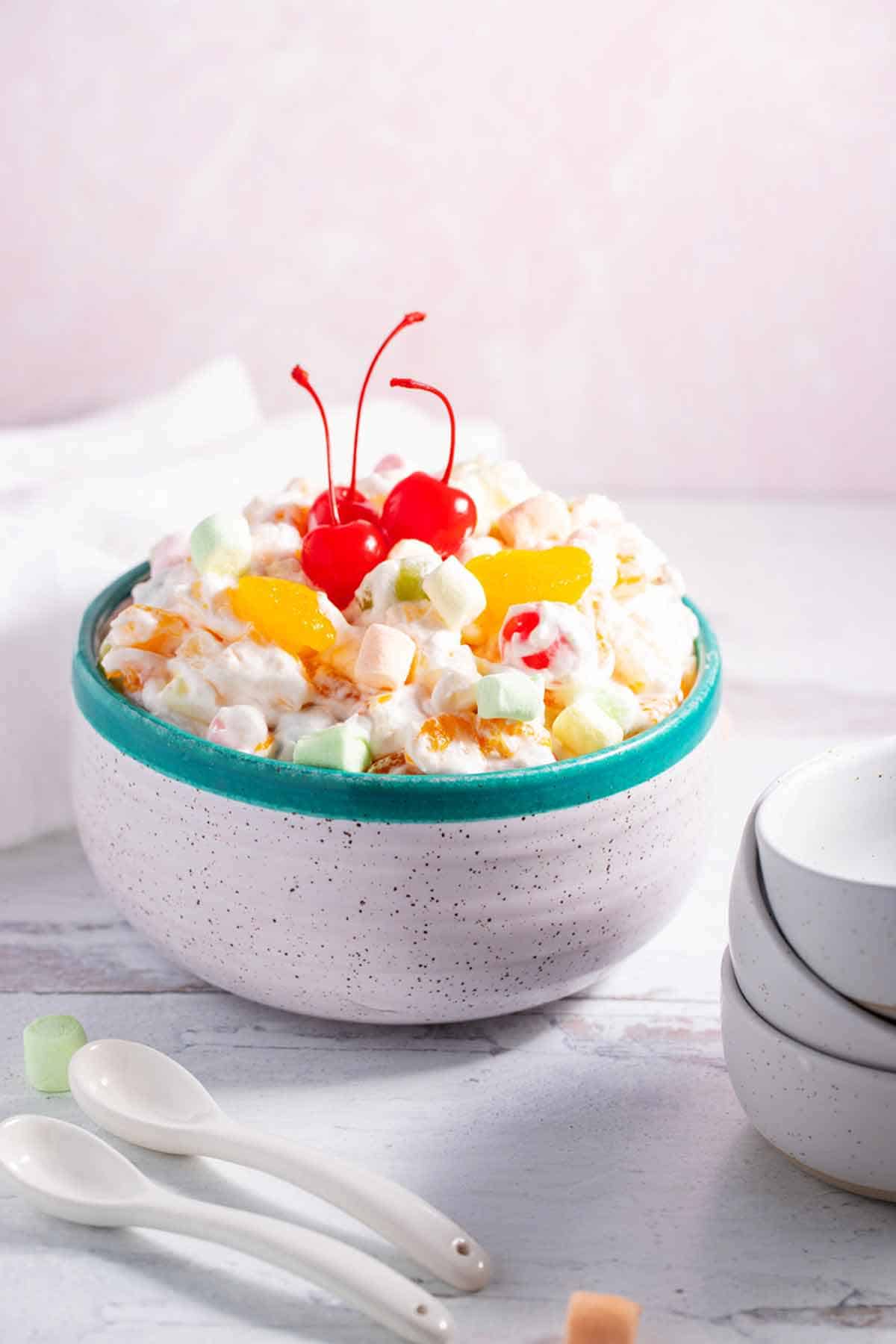 Ambrosia salad with small bowls and spoons next to it.