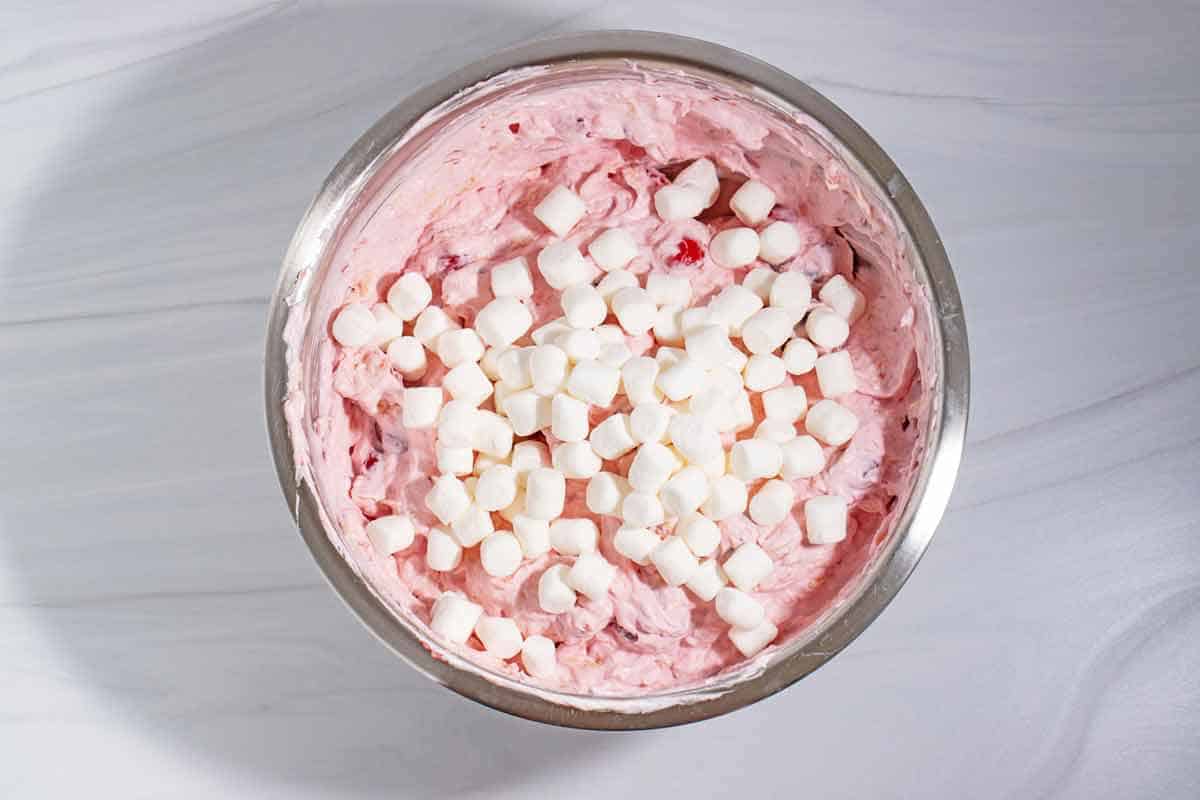 Marshmallows added to cherry fluff salad.