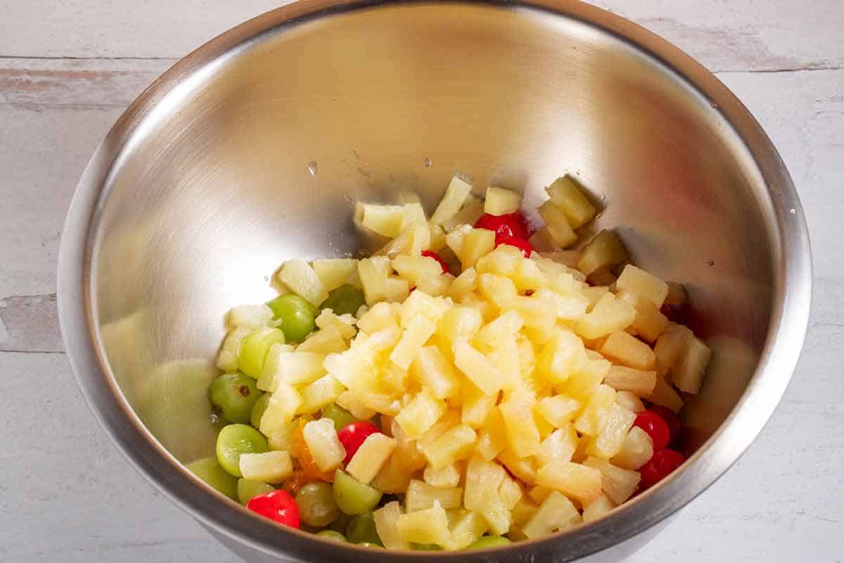 Ambrosia salad fruits in a large mixing bowl.