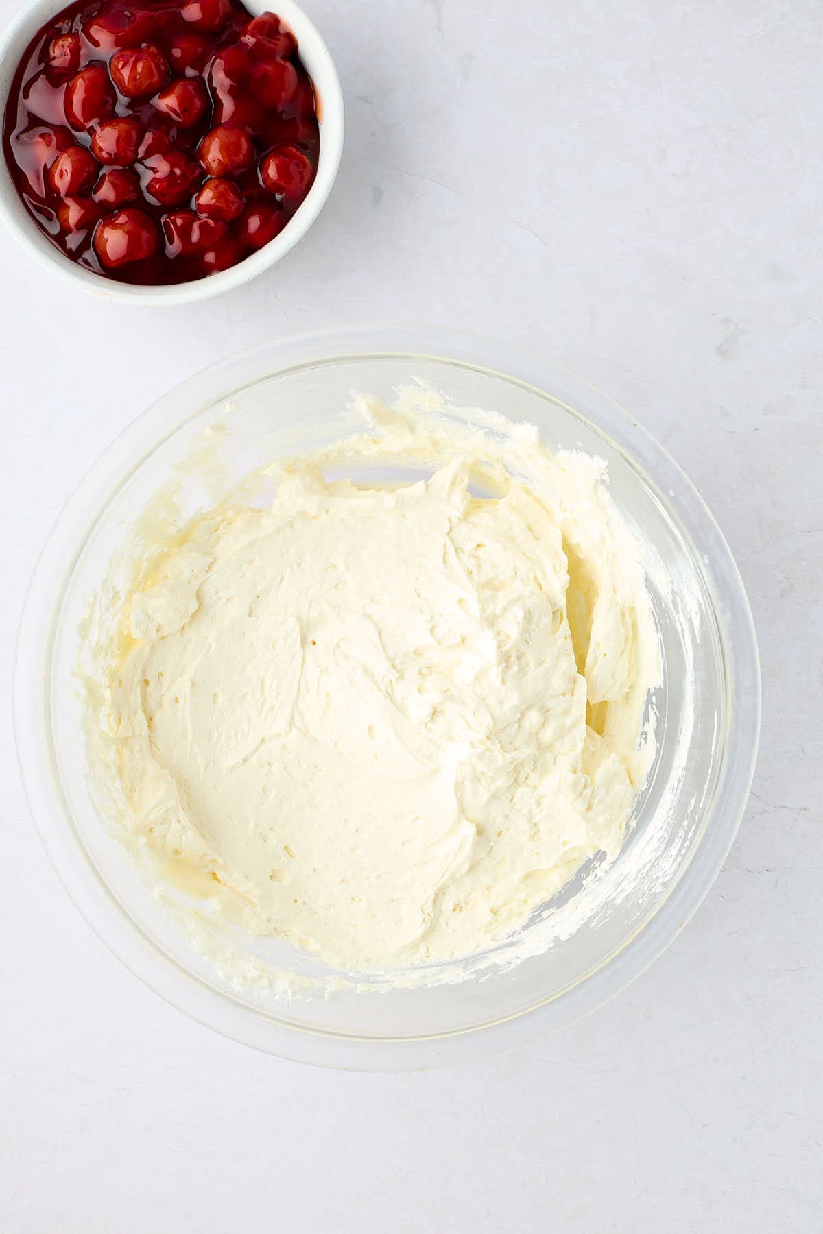 No-bake cream cheese filling with a bowl of cherries next to it.