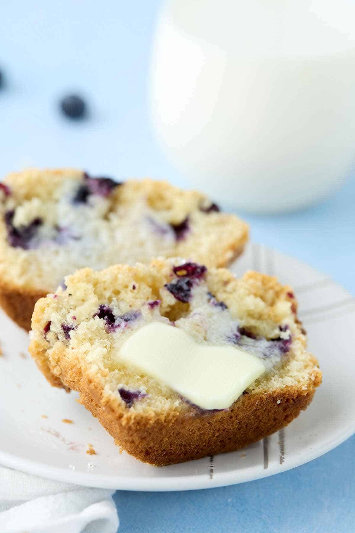 Cut blueberry muffin with melting butter on one half.