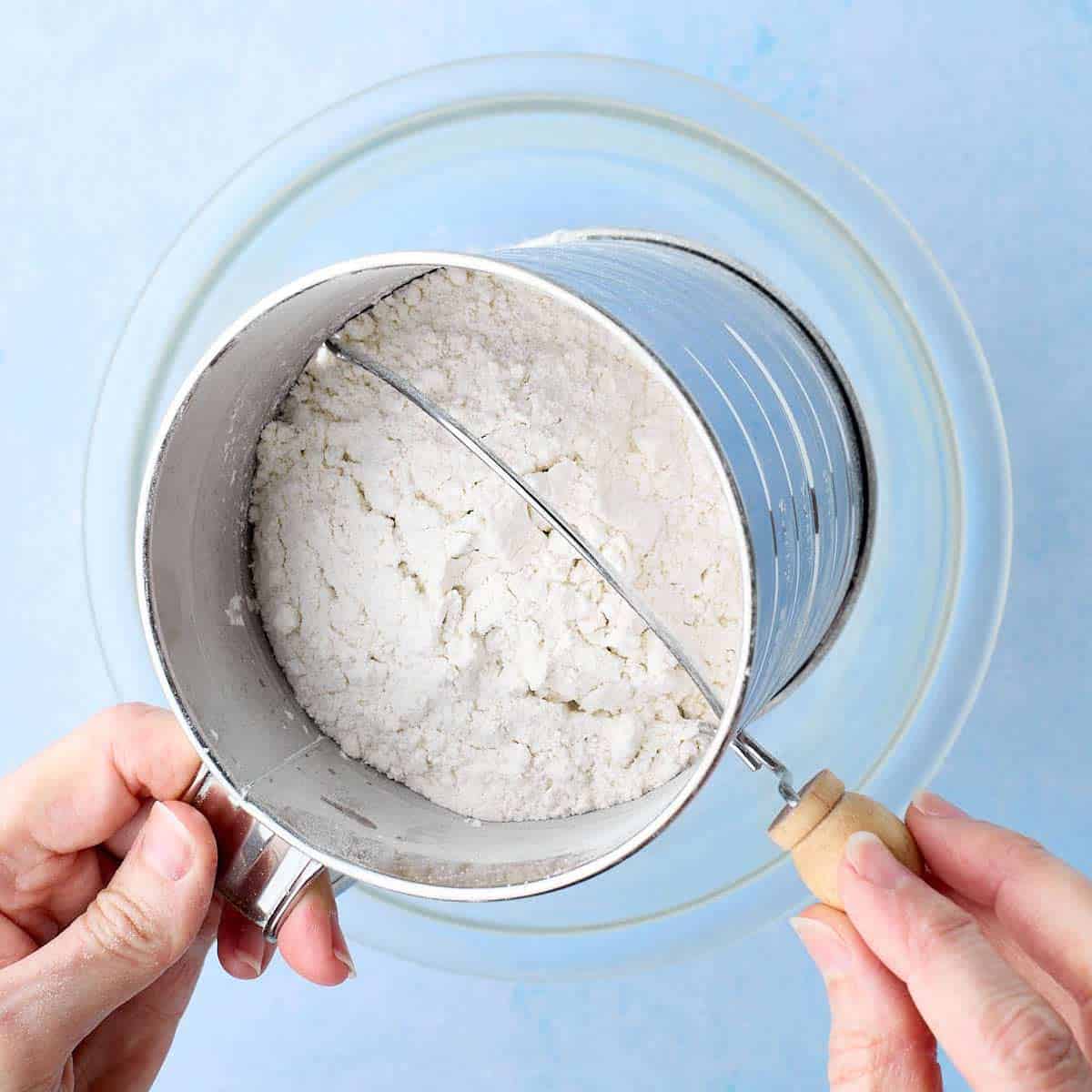 Sifting flour in a bowl.